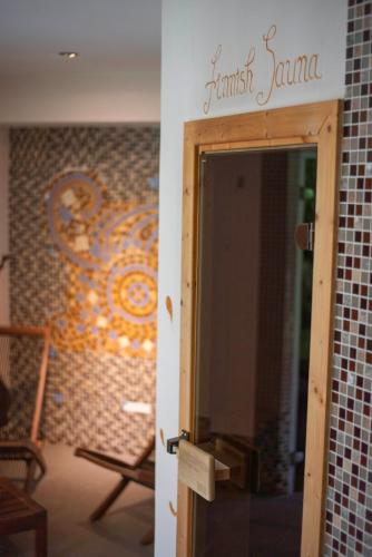 an open door to a room with a mosaic wall at Paj Hotelul Retreat & Spa in Sinaia
