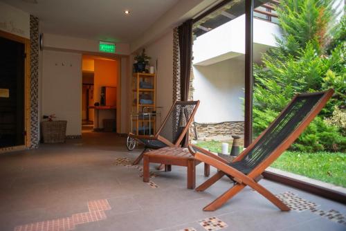 two rocking chairs sitting on a patio in front of a window at Paj Hotelul Retreat & Spa in Sinaia