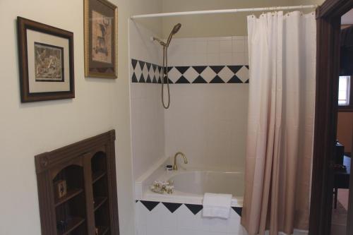 a bathroom with a tub and a shower curtain at Apple Crest Inn in Gentry