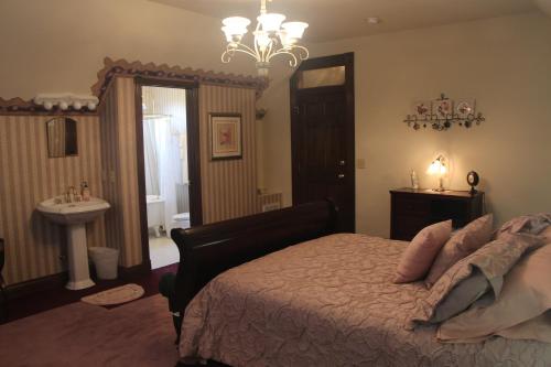 a bedroom with a bed and a sink and a chandelier at Apple Crest Inn in Gentry