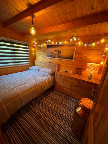 Ένα ή περισσότερα κρεβάτια σε δωμάτιο στο Rubys Retreat Stylish Log Cabin-Hidden Garden