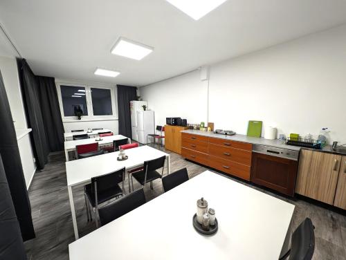 a kitchen with white tables and chairs in a room at Baraczek Lotnisko Leszno in Leszno