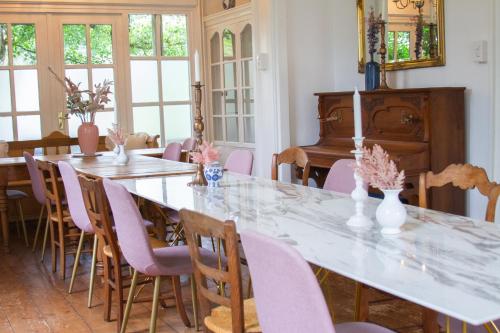 a dining room with tables and chairs and a piano at De Oude Pastorie Macharen in Macharen