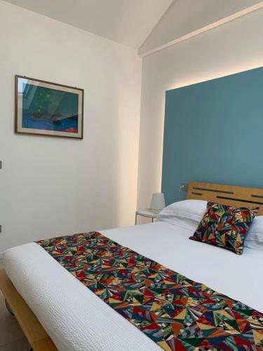 a bedroom with a bed with a colorful quilt on it at L'Attico in Cesano Maderno