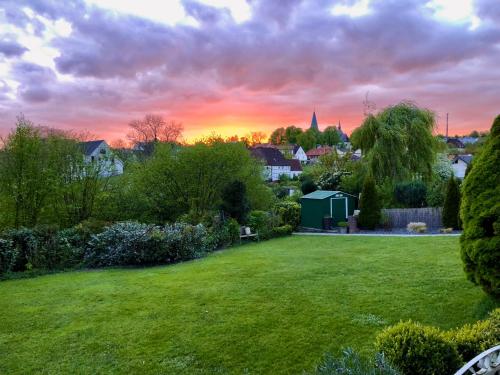 a view of a garden with a sunset in the background at Ferienwohnung Körbecke am Möhnesee in Möhnesee