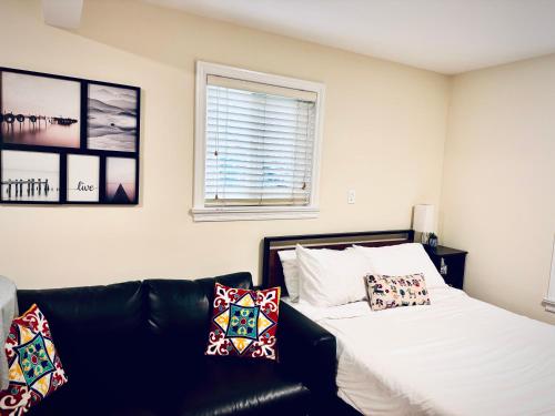 a bedroom with a bed and a couch with pillows at Cozy 2 beds Spacious rooms,Close to transit in Vancouver