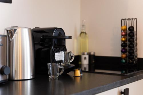 a kitchen counter with a coffee maker and two cups at L'audace T2 refait à neuf à Vanves in Vanves
