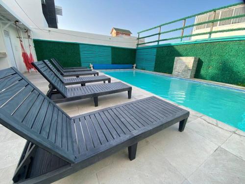 two benches sitting next to a swimming pool at Depto3 frente playa foro boca alberca in Boca del Río