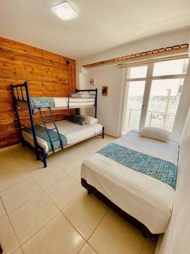a bedroom with two beds and a window at Depto3 frente playa foro boca alberca in Boca del Río