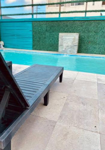 a bench sitting next to a swimming pool at Depto3 frente playa foro boca alberca in Boca del Río