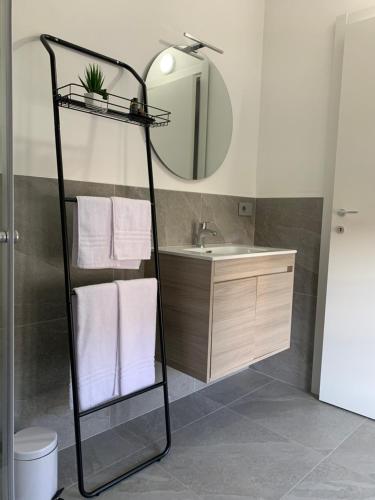 a bathroom with a sink and a mirror and towels at L'Attico in Cesano Maderno