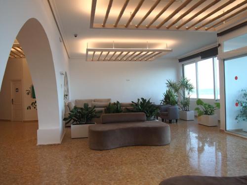 a living room with a couch and some plants at Hotel Roca Bella in Es Pujols