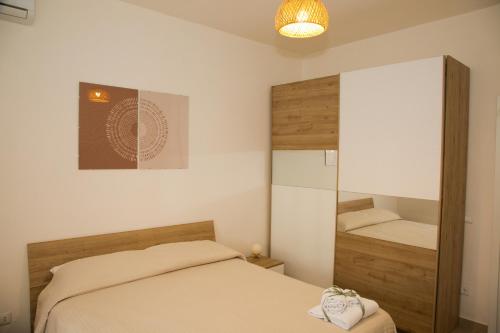 a small bedroom with a bed and a mirror at Le Floreali - Casa Salvia in Bolsena