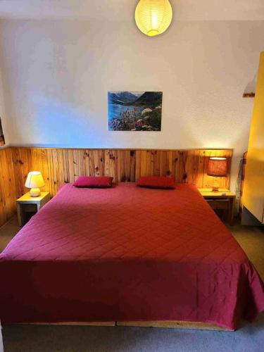 - une chambre avec un grand lit rouge et 2 oreillers rouges dans l'établissement Résidence Les Arolles - LES AROLLES-AR11A MAE-7951, à Villarodin-Bourget