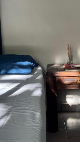 a bed and a wooden table next to a bed and a desk at Casa Mango Confort in Mérida