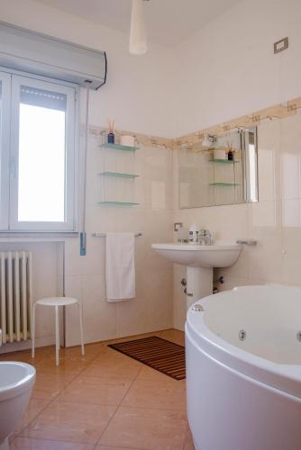 a white bathroom with a tub and a sink at La Vista Incantata in Comiso