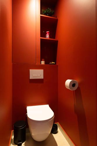 a bathroom with a white toilet in a red wall at L'audace T2 refait à neuf à Vanves in Vanves