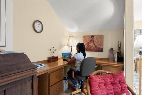 a woman sitting at a desk with a laptop at New 4 Bedroom Lithonia Home With Office in Lithonia