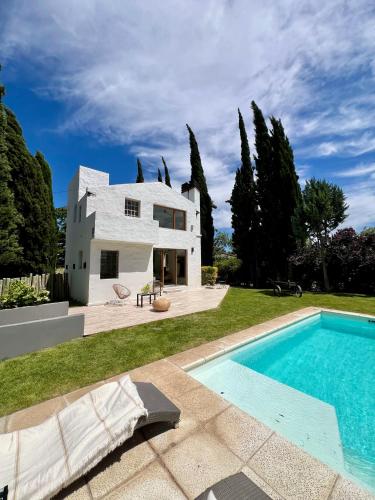 ein weißes Haus mit einem Swimmingpool davor in der Unterkunft Hospedaje Patagonia in Bahía Blanca