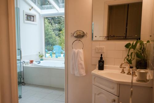 a bathroom with a tub and a sink and a bath tub at Azalea Cedar-Rose Barossa Valley Villa in Lyndoch