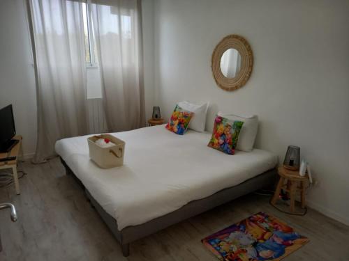 a bedroom with a white bed with a bag on it at B309 Appartement proche Disney Paris in Montévrain