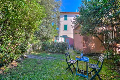 Dos sillas y una mesa en un patio. en La Fresia - Focette 100m from sea - Happy Rentals, en Pietrasanta