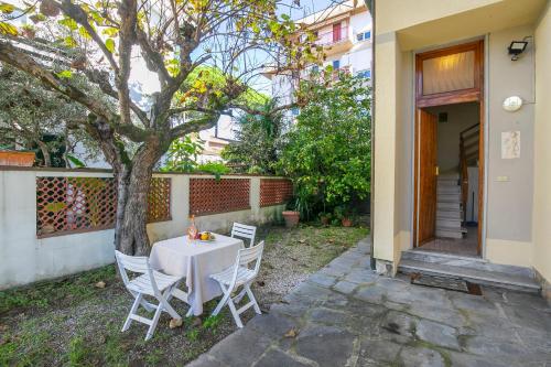 a table and chairs sitting next to a tree at Casa Vittoria 800m from sea - Happy Rentals in Forte dei Marmi