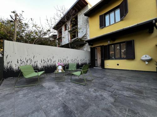 a group of chairs sitting on a patio next to a building at The One Malpensa Rooms in Vizzola Ticino