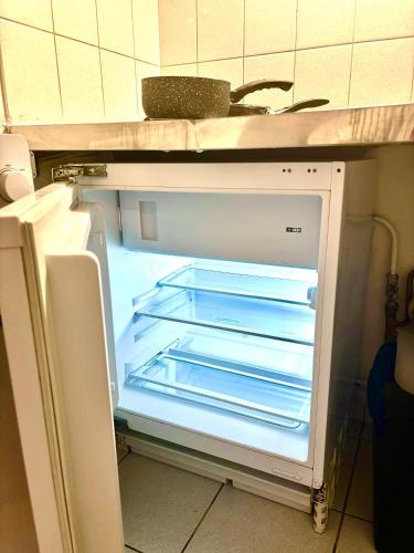 un réfrigérateur vide avec sa porte ouverte dans une cuisine dans l'établissement Suite de charme proche de la gare-internet haut débit, à Reims