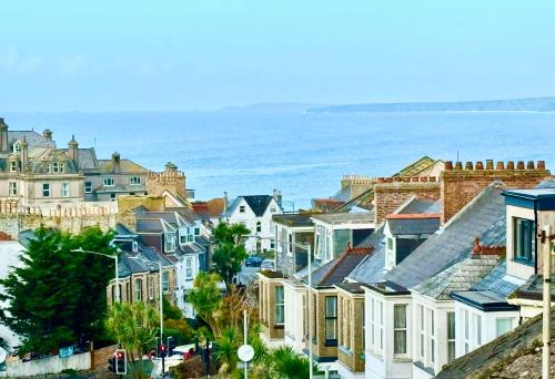 a group of houses on a hill next to the ocean at Seaview Surf Studios in Newquay