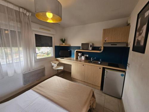 a small kitchen with a bed and a sink at 302 Studio Cosy sur Perpignan in Perpignan