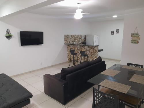 sala de estar con sofá, mesa y chimenea en Arraial do Cabo - Praia do Pontal, en Arraial do Cabo