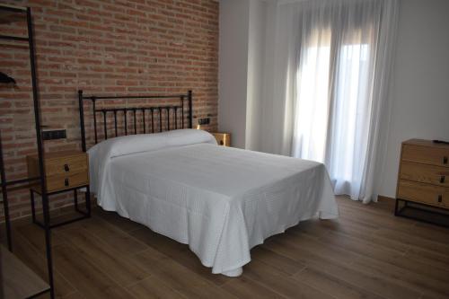 a bedroom with a bed and a brick wall at Alojamiento Rural La Josefa de los Arribes in Fermoselle