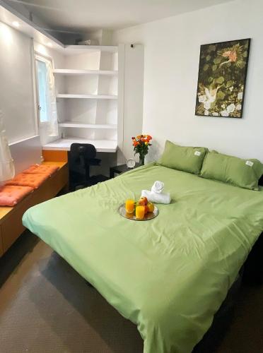 - un lit vert avec une assiette de fruits dans l'établissement Studio The Champs-Élysées, à Paris