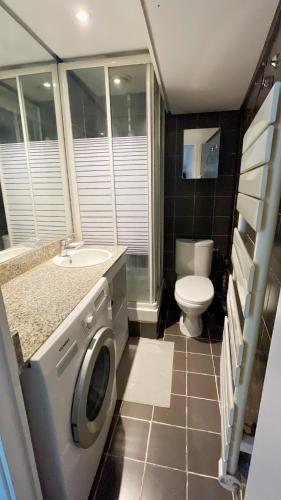 une salle de bain avec un lavabo et une machine à laver dans l'établissement Studio The Champs-Élysées, à Paris