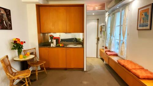 une cuisine avec des armoires en bois et une table et des chaises dans l'établissement Studio The Champs-Élysées, à Paris