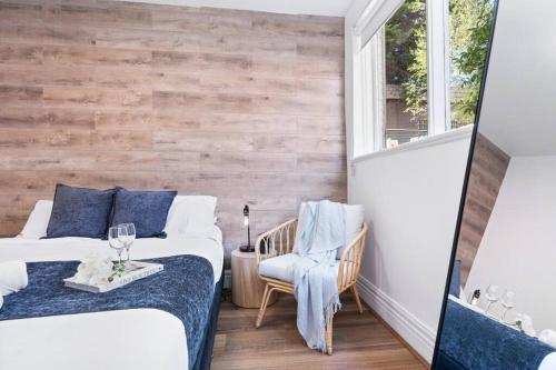 a bedroom with two beds and a wooden wall at Cozy 1 bedroom apartment - Caulfield park in Melbourne