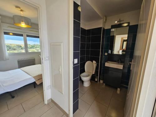 une salle de bain avec un lit, des toilettes et un lavabo dans l'établissement 223 Studio Cosy a Perpignan, à Perpignan
