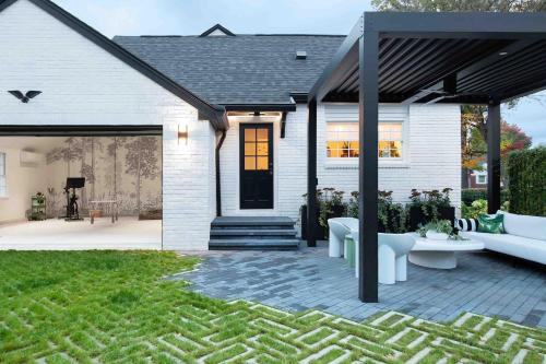 a white house with a black door and a patio at Ivy Grace - 4 Br, Stylish, Pet-friendly Retreat in Indianapolis