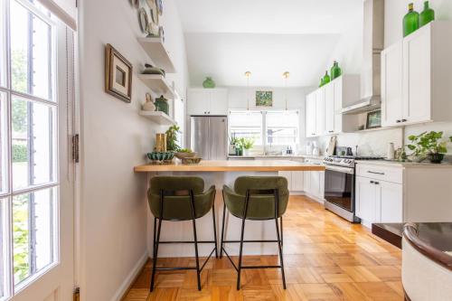 een keuken met witte kasten en groene barkrukken bij Ivy Grace - 4 Br, Stylish, Pet-friendly Retreat in Indianapolis