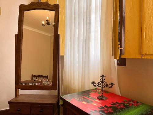 a mirror on a dresser next to a dresser with a table with at Casarão Solar dos Almeida in Diamantina