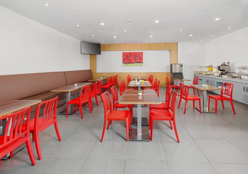a dining room with red chairs and tables in a restaurant at Hotel México Plaza Irapuato in Irapuato