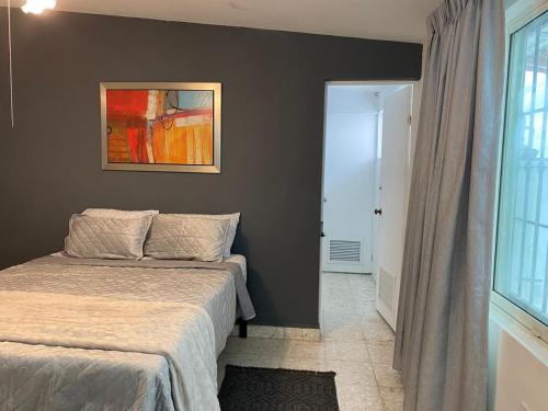 a bedroom with a bed and a painting on the wall at Luna Menguante in Monterrey