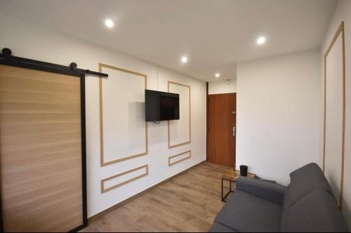 - un salon avec un canapé et une télévision murale dans l'établissement Prado Marseille 8eme studio, à Marseille