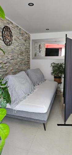 un lit dans une chambre avec un mur de briques dans l'établissement Appartement moderne à Nice, 50 m² avec balcon, à Nice