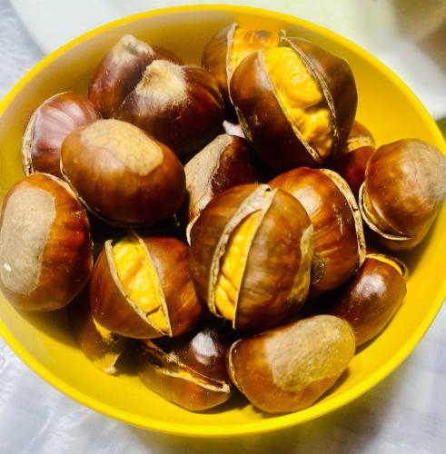 a yellow bowl full of chestnuts on a table at Casa da Burra in Alijó