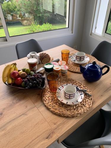 een houten tafel met een fruitschaal erop bij Villa Ongizatea au calme avec piscine et vue montagne in Urrugne