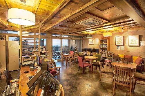 ein Restaurant mit Tischen und Stühlen in einem Zimmer in der Unterkunft Jeju Eco Suites in Seogwipo