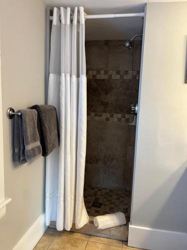 a shower with a shower curtain in a bathroom at Abalonia Inn in Ogunquit