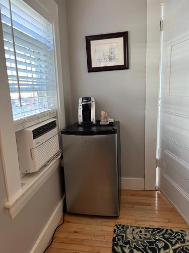 a small refrigerator in a room with a window at Abalonia Inn in Ogunquit